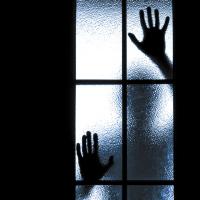 Silhouette of person behind glass door